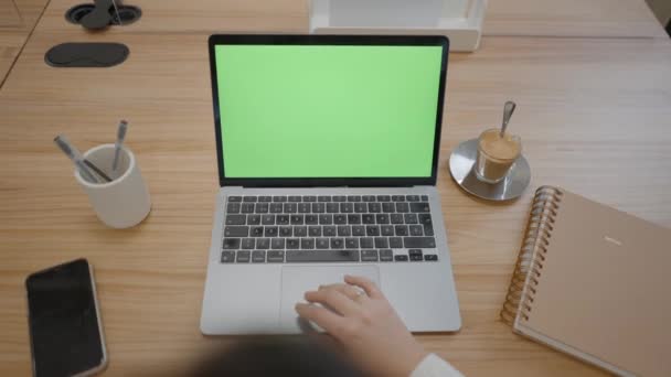 Ruka ženy dotýkající se touchpadu notebooku s chromakey zelenou obrazovkou v kooperativní kanceláři - pullback — Stock video