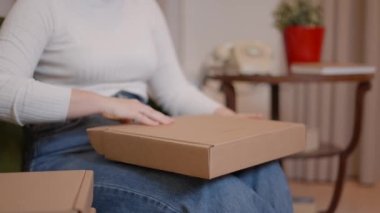 Kadın girişimcinin elleri teslimattan önce paket kutularını kontrol ediyor.