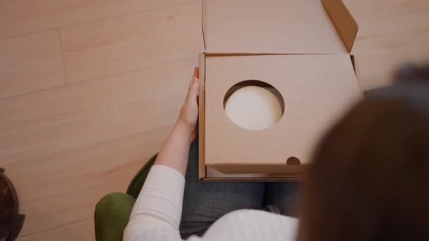 Zelfstandige vrouwelijke ondernemer verpakking product in een doos of pakket voor levering - over de schouder bovenaanzicht — Stockvideo