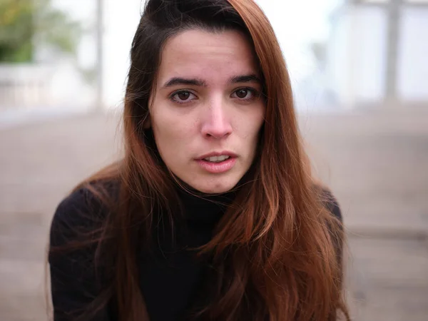 Una joven triste mirando a la cámara llorando con un fondo fuera de foco. — Foto de Stock