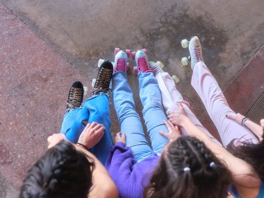 Klasik paten giyerek dışarıda oturan üç genç kadının en iyi görüntüsü.