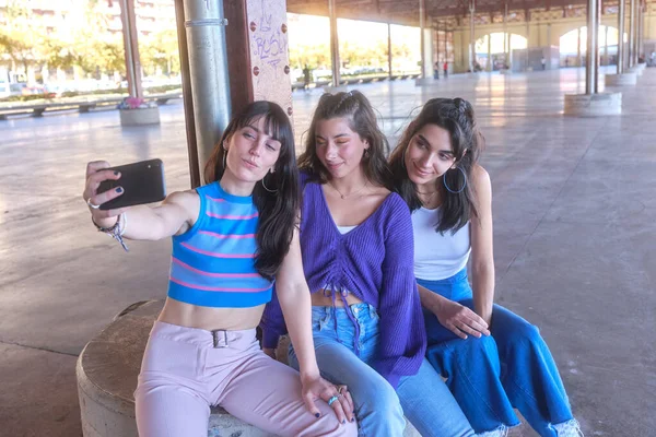 Freunde machen ein Selfie mit dem Handy, während sie im Stadtgebiet sitzen — Stockfoto