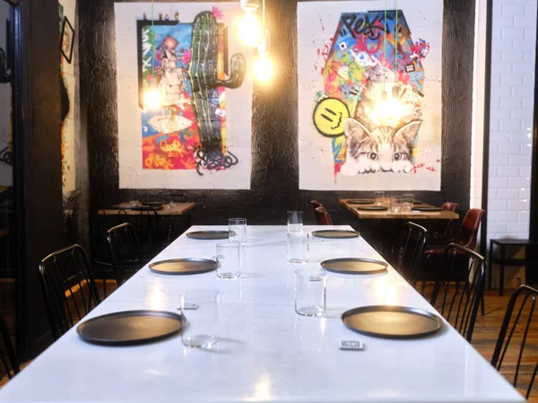 Стол ресторана с современной живописью на заднем плане — стоковое фото
