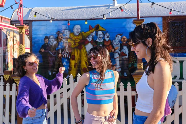 Três amigos sorridentes com roupas vintage ao lado de um desfile de circo ao ar livre — Fotografia de Stock