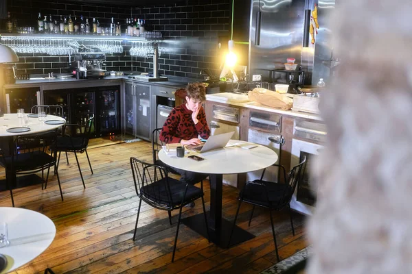 Selective focus on a manager working with a laptop inside a restaurant — Stock Photo, Image