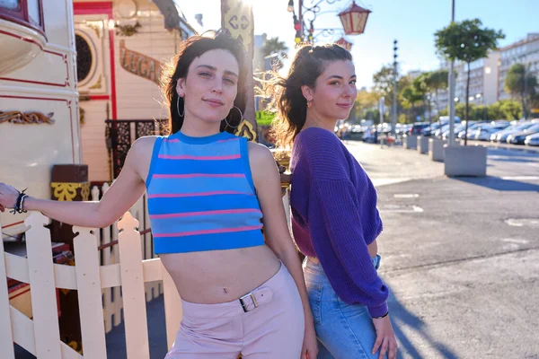 Dvě dívky s vintage oblečení pózovat na ulici vedle cirkusového průvodu — Stock fotografie