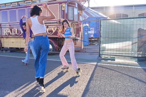 Vrienden dansen op schaatsen in de straat naast een circus in de zomer — Stockfoto