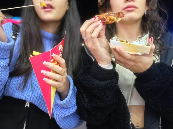 Close up view of two women eating fast food outdoors — Stock fotografie