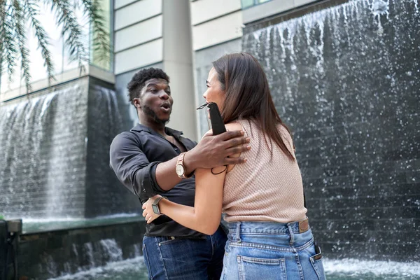 Zwei Freunde verschiedener Ethnien treffen sich in einem Einkaufszentrum wieder — Stockfoto