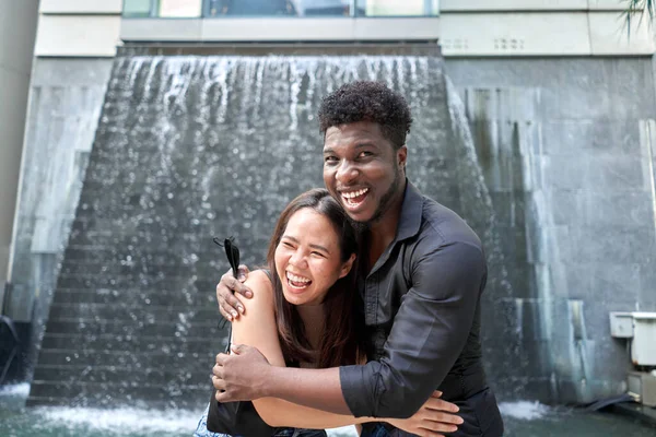 Dois amigos multiétnicos abraçando com uma expressão feliz ao ar livre — Fotografia de Stock