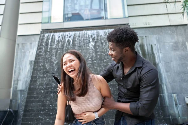 Asiatin lacht neben einem afrikanischen Freund in einem Einkaufszentrum — Stockfoto