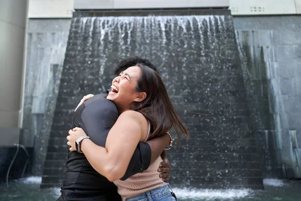 Close up retrato de amigos multiétnicos abraçando em um shopping moderno — Fotografia de Stock