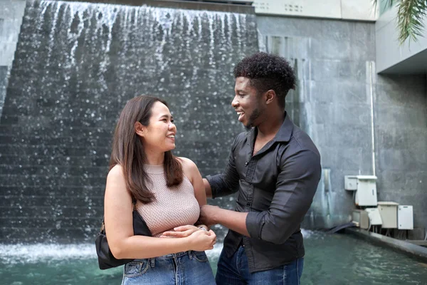 Smiling friends of different ethnicities standing and talking in a shopping mall — Stock Photo, Image