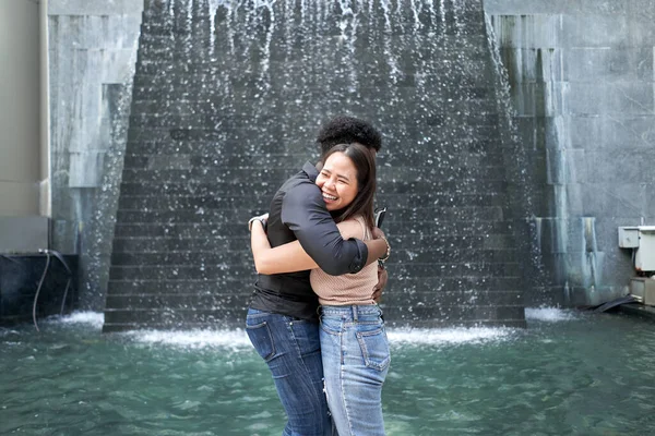 Amigos de diferentes etnias abraçando fora de um shopping — Fotografia de Stock