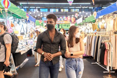 İki çok ırklı arkadaş alışveriş merkezindeki dükkanları ziyaret ediyor.