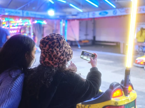 Dos amigos tomando una foto de los coches locos en una feria — Foto de Stock