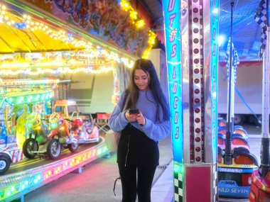 Çılgın bir arabanın yanında cep telefonu kullanan bir kadın.