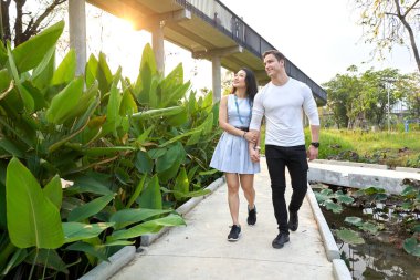 Çok ırklı bir çift gün batımında bir şehir parkında yürürken dikkatleri dağılıyor.