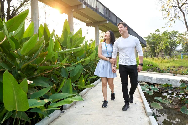 Çok ırklı bir çift gün batımında bir şehir parkında yürürken dikkatleri dağılıyor.