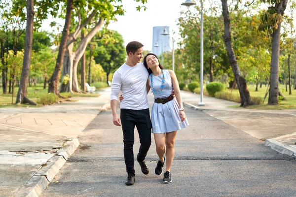 Newly married couple strolling through a city park during sunset — Foto Stock