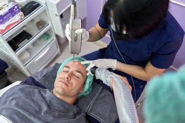 Hasta cildini gençleştirmek için lazer tedavisi görüyor.