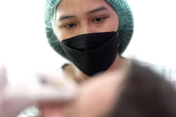 Retrato de una enfermera mirando a un paciente que recibe un tratamiento de belleza — Foto de Stock