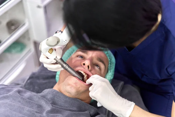 Patient with mouth open while undergoing intraoral facial rejuvenation treatment — Stockfoto