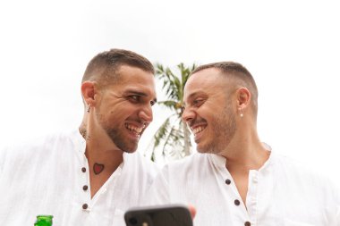 Eşcinsel çift dışarıda gezerken birbirlerine nazikçe bakıyorlar.