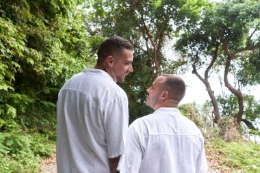 Ormanda bir patikada yürüyen eşcinsel bir çiftin yakın görüntüsü.