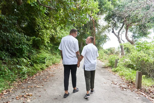 Gay coppia passeggiando lungo un foresta pluviale percorso tenendo per mano — Foto Stock