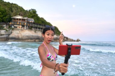 Dolunay partisinde canlı performans sergilerken Ay 'ı işaret eden etkici