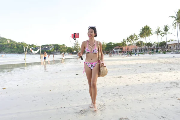 Sahilde yürürken cep telefonu kullanarak canlı yayın yapan nüfuzlu biri.