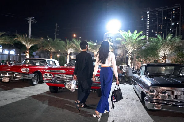 Casal lésbico passeando por uma feira noturna com carros antigos — Fotografia de Stock