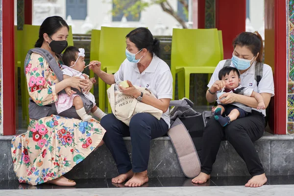 Bangkok, Tayland, 16 Şubat 2022: Bebekli üç kadın sokakta onları beslerken