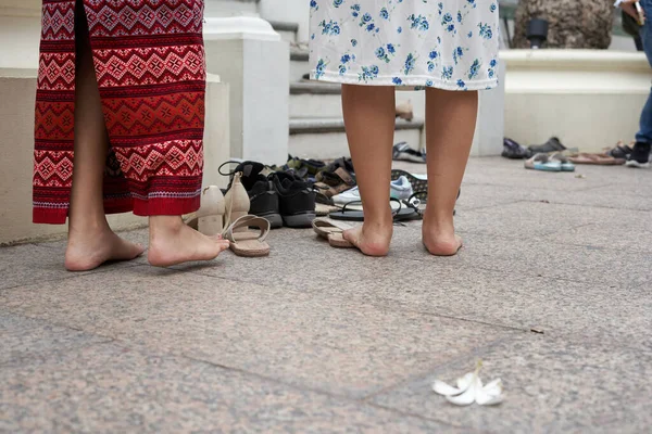 Bangkok, Tayland, 16 Şubat 2022: Makha Bucha Günü boyunca Budist tapınağında dua eden iki kişinin çıplak ayakları