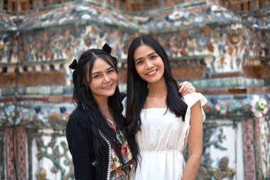 Tayland 'daki Wat Arun tapınağındaki kameraya bakan iki Asyalı arkadaşın portresi.