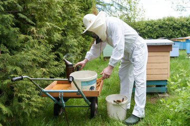 Çiftlikte el arabasıyla çalışan bir arıcının portresi.