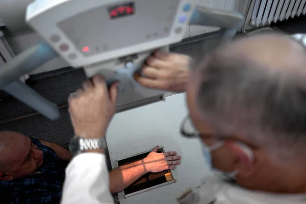 Hand Eines Patienten Auf Einer Röntgenplatte Während Ein Arzt Bilder lizenzfreie Stockbilder