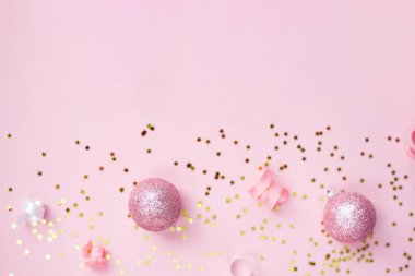 Pembe arka planda altın sarısı ve beyaz noel süslemeleri. Yeni yıl ya da parti afişi