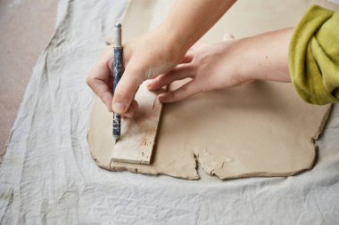 Çömlek atölyesinde çalışan kadın seramik. Seramikçinin Elleri Kirli Çamur. Çömlek yapma süreci. Usta seramist onun stüdyosunda çalışıyor.