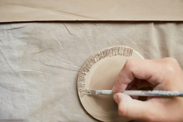 Çömlek atölyesinde çalışan kadın seramik. Seramikçinin Elleri Kirli Çamur. Çömlek yapma süreci. Usta seramist onun stüdyosunda çalışıyor.