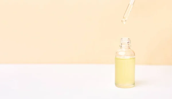 Beyaz ve sarı arka planda, şişenin üzerinde gerekli yağ bulunan boru. Doğal tıp konsepti. Aromaterapi 