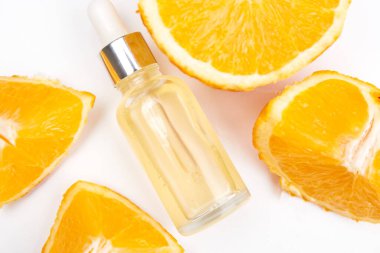 Portakallar ve temel yağ beyaz arka planda. Doğal tıp konsepti. Aromaterapi