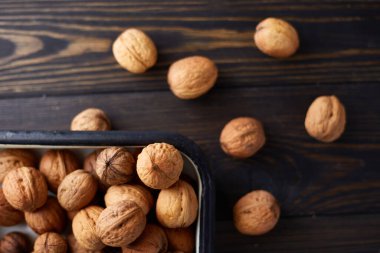 Koyu ahşap masada doğal cevizler. Üst görünüm, kopyalama alanı olan düz uzanma