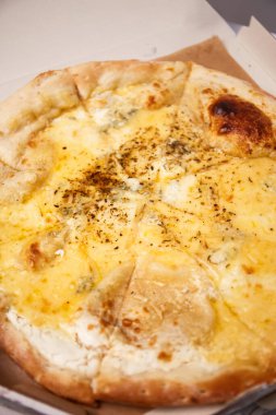 Bir dilim sıcak pizza. Çedar peyniri, parmesan peyniri, mozzarella ve domates soslu. Vejetaryen pizza.