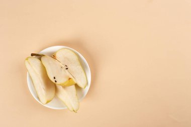 Düz kompozisyon, olgun armutlar, pastel sarı arka plan, üst manzara. Metin için boşluk