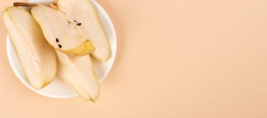 Düz kompozisyon, olgun armutlar, pastel sarı arka plan, üst manzara. Metin için boşluk