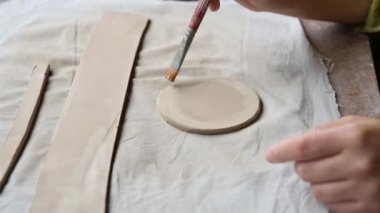 Çömlek atölyesinde çalışan kadın seramik. Seramikçinin Elleri Kirli Çamur. Çömlek yapma süreci. Usta seramist onun stüdyosunda çalışıyor.