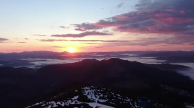 Gün doğumunda dağlarda sisli havada uçmak. Karlı Dağ Sırası Silueti Gün Doğumu Hava Görüntüsü