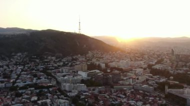 Tiflis şehir merkezinin hava görüntüsü. İnsansız hava aracı gün batımında eski kasabanın üzerinde uçar. Sakartvelo